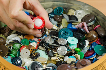 Image showing Dish of colorful buttons and finger pick 