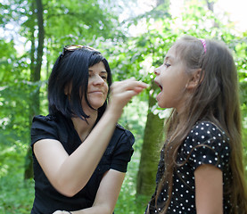 Image showing Mother feeding daughter