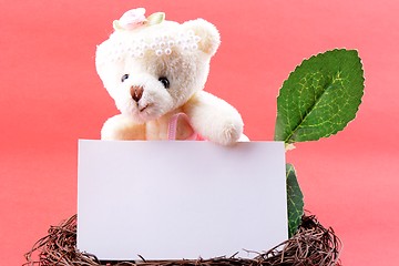 Image showing Nest with a blank card and teddy bear