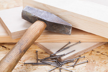 Image showing Mallet with nails and planks of new wood