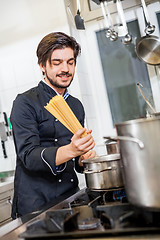 Image showing Attractive friendly chef preparing spaghetti