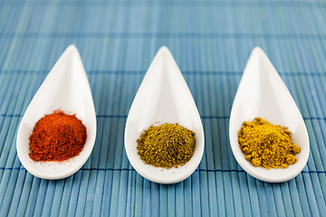 Image showing Dried ground spices in ceramic spoons