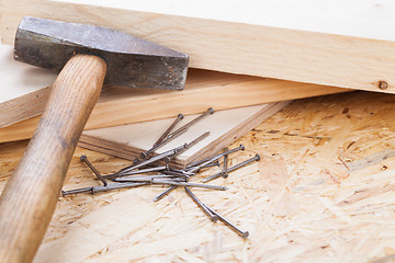 Image showing Mallet with nails and planks of new wood