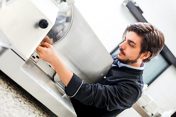 Image showing Commercial cook or chef slicing cold meat