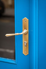 Image showing Brass door handle on a colorful blue door