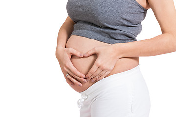 Image showing Young pregnant woman making a heart gesture