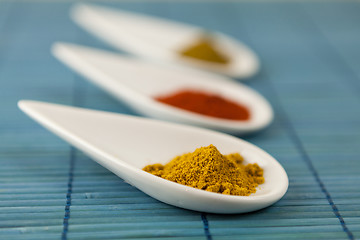 Image showing Dried ground spices in ceramic spoons