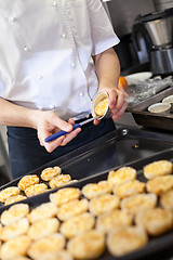 Image showing Chef preparing desserts removing them from moulds