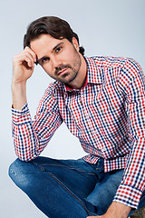 Image showing Handsome young man sitting on a wooden box