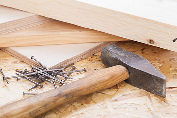 Image showing Mallet with nails and planks of new wood