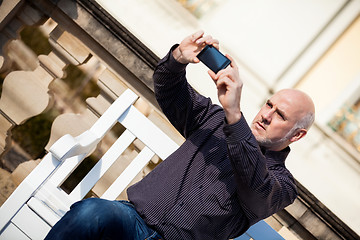 Image showing Man taking a photograph with his mobile