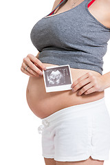 Image showing Pregnant woman displaying a prenatal ultrasound