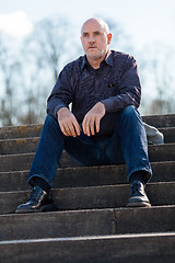 Image showing Thoughtful man sitting on a flight of steps