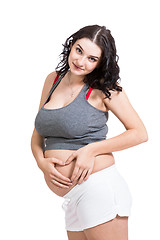 Image showing Young pregnant woman making a heart gesture