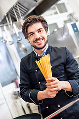 Image showing Attractive friendly chef preparing spaghetti