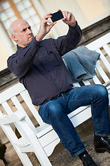 Image showing Man taking a photograph with his mobile