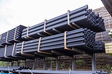 Image showing Rolls of plastic pipes in a warehouse yard