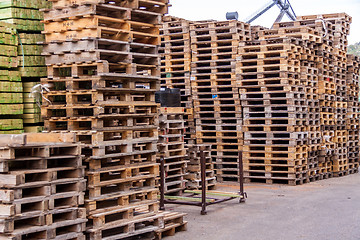 Image showing Stacks of old wooden pallets in a yard