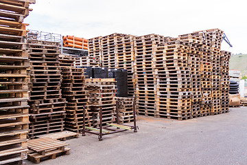 Image showing Stacks of old wooden pallets in a yard