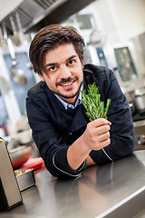 Image showing Chef checking the freshness of a bunch of herbs