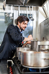 Image showing Chef stirring a huge pot of stew or casserole