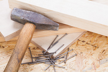 Image showing Mallet with nails and planks of new wood