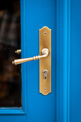 Image showing Brass door handle on a colorful blue door