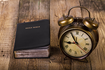 Image showing Bible with clock on wood