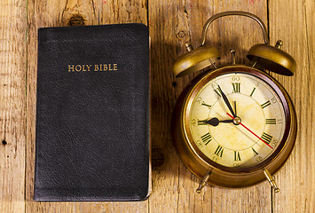 Image showing Bible with clock on wood
