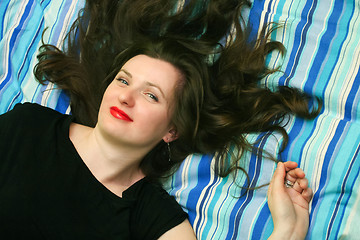 Image showing Young woman resting on bed