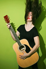 Image showing Woman with rock guitar shaking hair 