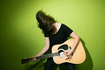 Image showing Woman passionately playing guitar