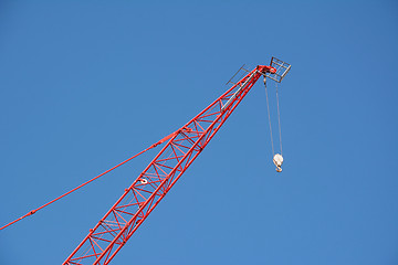 Image showing Red crane boom against a blue sky