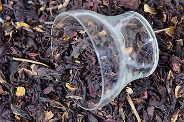 Image showing black herbal tea pile background and cup 