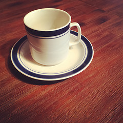 Image showing White cup on a wooden table