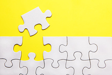 Image showing White puzzle pieces on yellow background