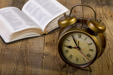 Image showing Bible with clock on wood