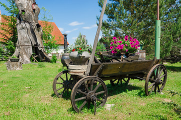 Image showing rustic wooden carriage with flower composition  