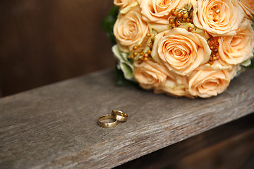 Image showing Apricot color bridal bouquet with wedding rings