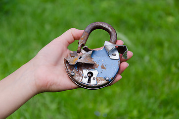 Image showing old rusty broken door lock on man hand outdoor 