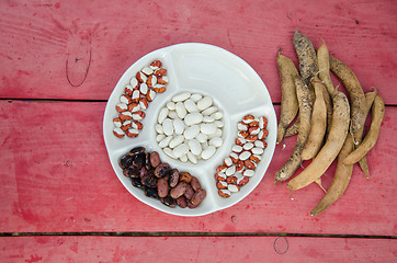 Image showing beans in plate few full pods on the table outdoor 