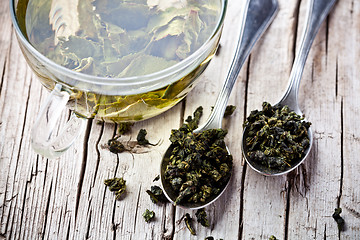 Image showing cup of green tea and spoons 