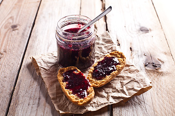 Image showing black currant jam in glass jar and crackers