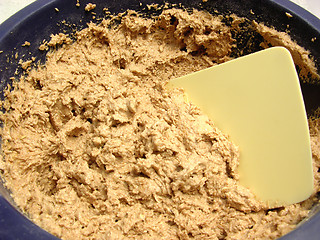 Image showing Mixed unbaken chocolate dough in a bowl with dough scraper