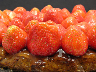 Image showing Lateral close-up view of a strawberry cake on black background