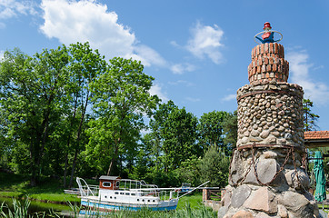 Image showing stone brick lighthouse in summer park on blue sky 