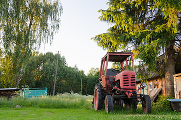 Image showing village farm red old tractor in meadow summer time 