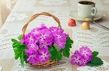 Image showing Wattled basket with blossoming violets on a table.