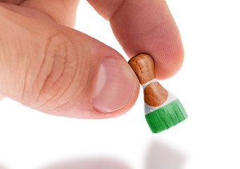 Image showing Hand holding wooden pawn, flag painting, selective focus