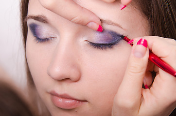 Image showing Makeup artist paints eyelashes with makeup. Close-up